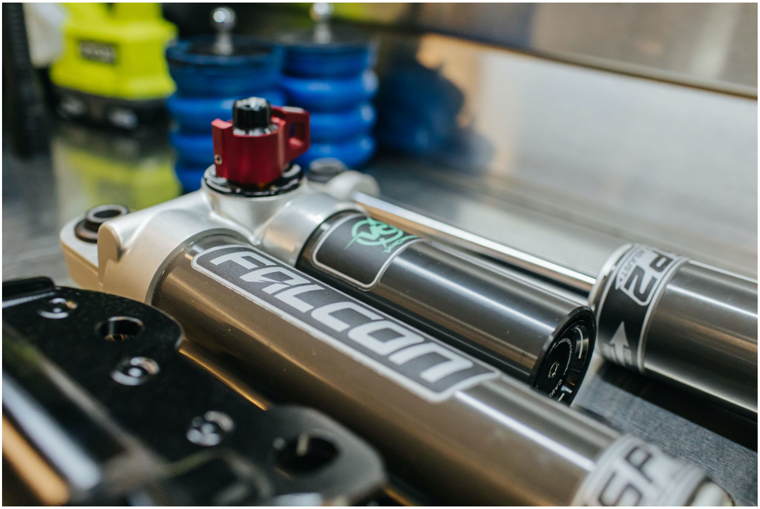 Close-up of a silver machine component featuring black cylindrical pipes and intricate mechanical parts.