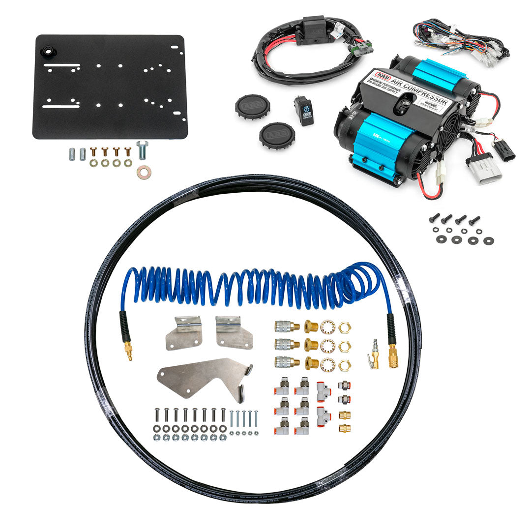 A black and blue air compressor connected to a blue hose, surrounded by various wires and cables.