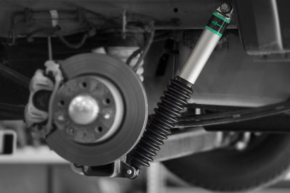 Close-up of a vehicle's suspension system with a focus on the shock absorber and wheel.