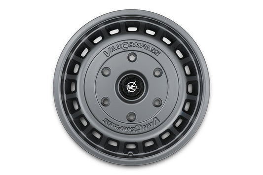 A dark gray metallic Van Compass wheel, shown from a top-down perspective on a solid white background.